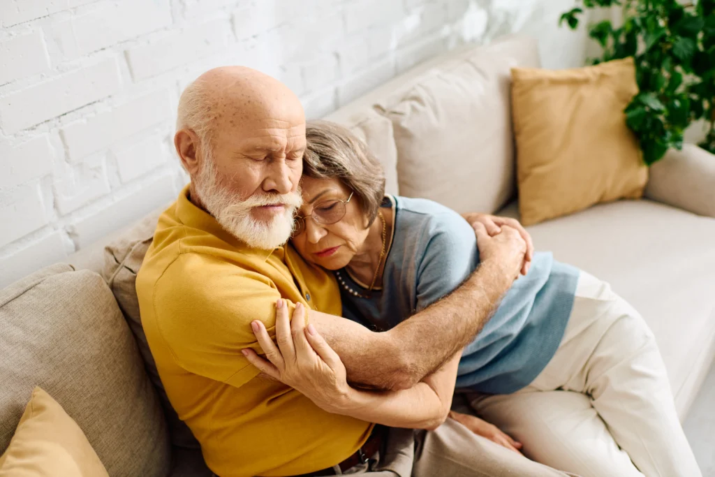An elderly couple relaxes on a couch, embodying love and togetherness in their serene living space