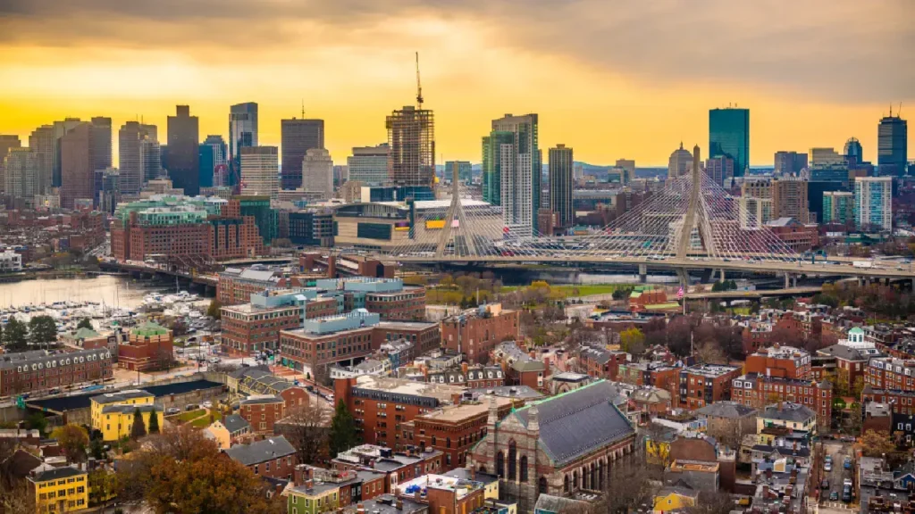 Boston skyline at sunset, highlighting iconic buildings and warm hues of resilience and hope