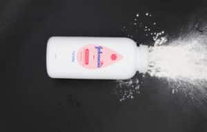 A Johnson & Johnson bottle releases powder into a small pile below