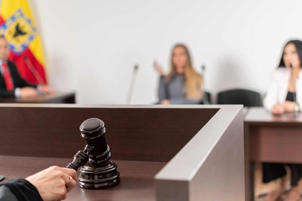 A judge at a desk with a gavel presiding over a courtroom