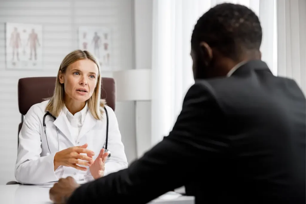 A female doctor in a white coat consults a male patient