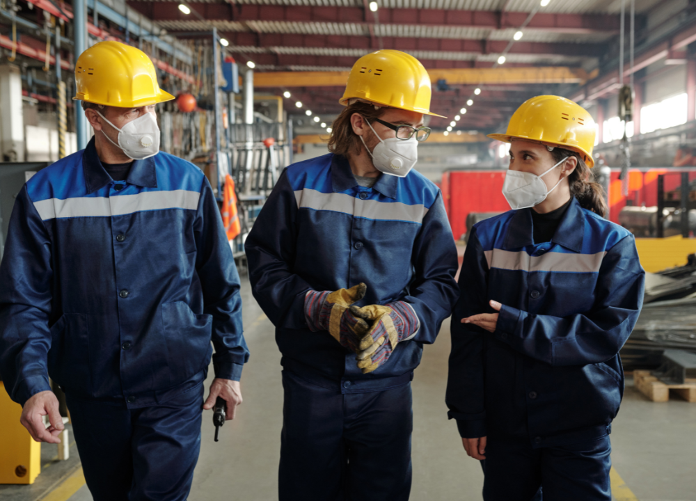 Workers wearing protective gear while handling asbestos materials.