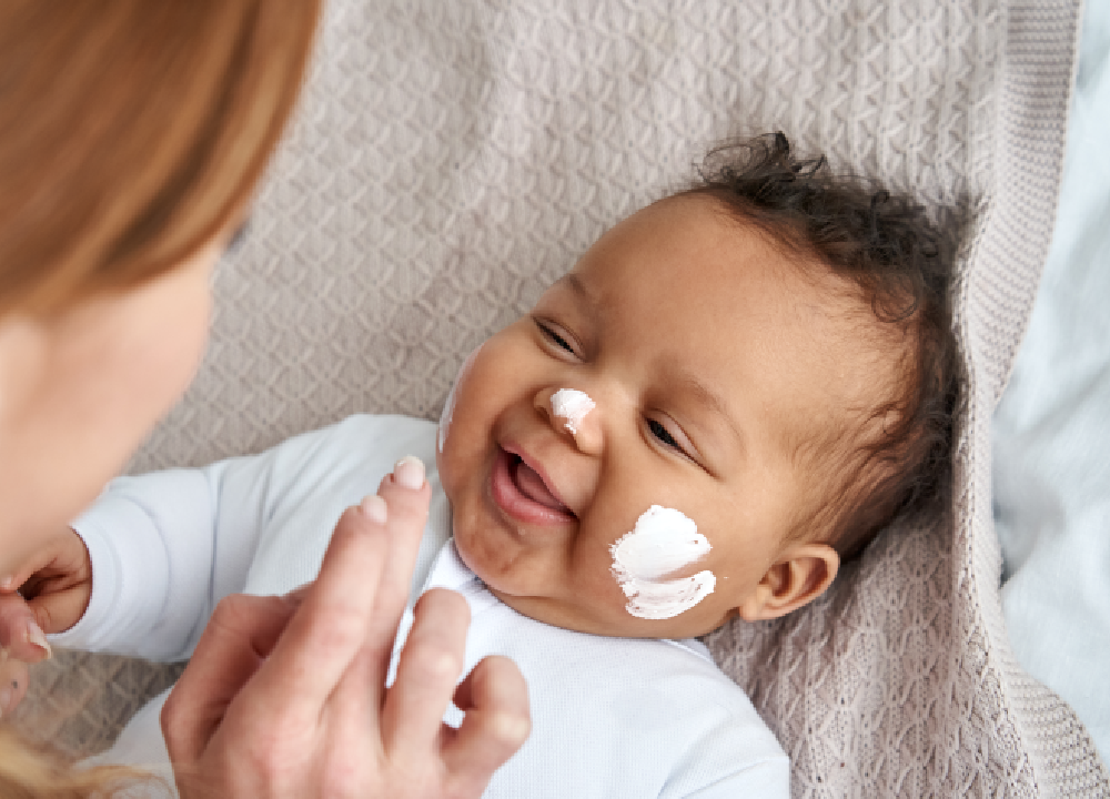 mother applying talcum powder to her baby
