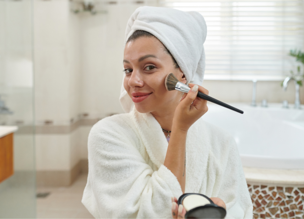 woman applying makeup with a powder brush