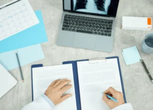 flat lay of medical files, CT scan images, and doctor's notes