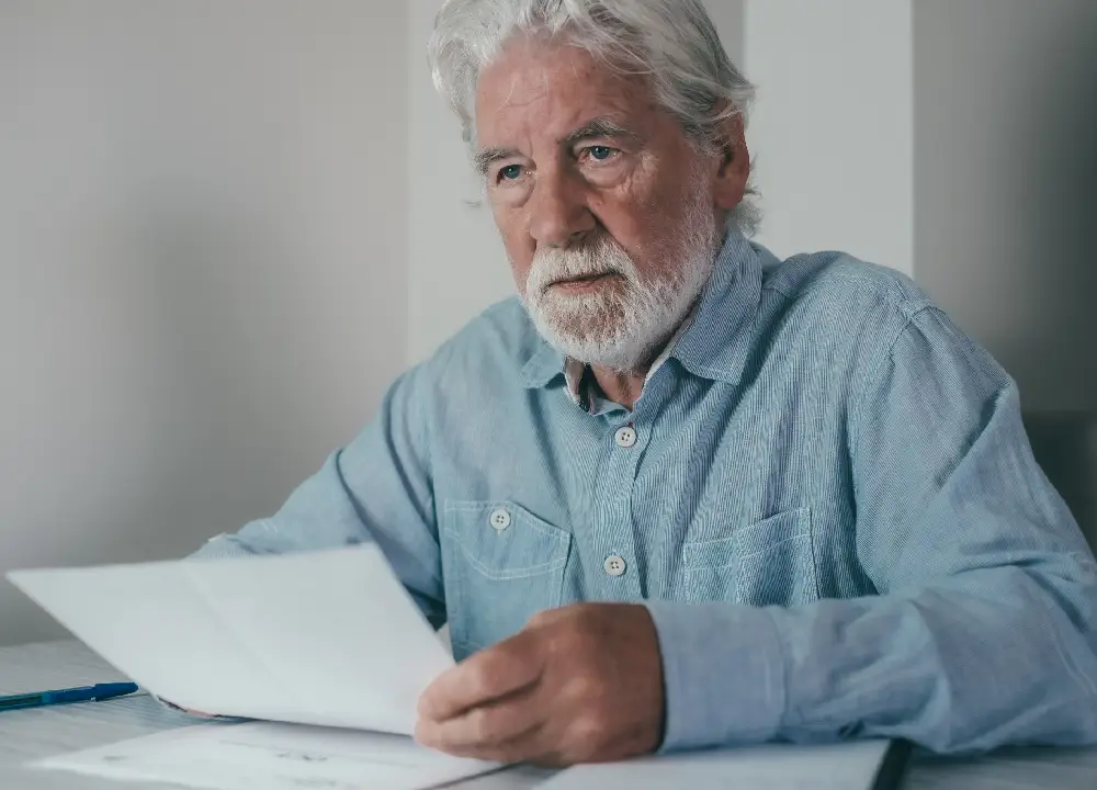 Old pre-printed asbestos claim document on a desk with a pen nearby.